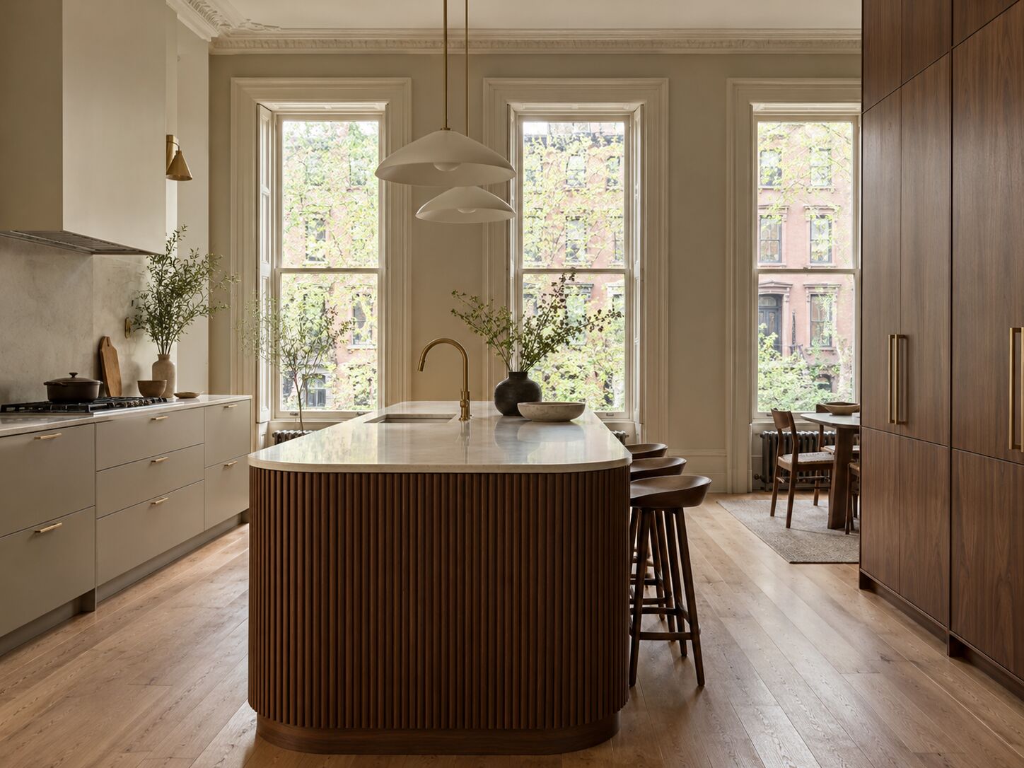 Brownstone kitchen with a curved fluted walnut island and full-height walnut pantry wall